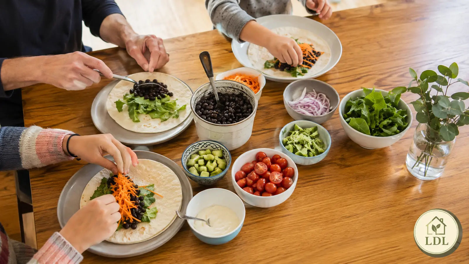 A family assembling a simple tortilla meal together at the dining table.